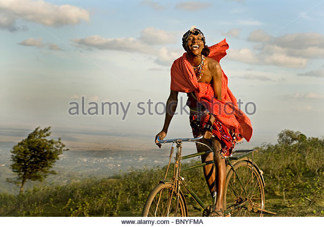 a-masai-tribesman-joyfully-rides-his-bike-through-the-hills-overlooking-bnyfma
